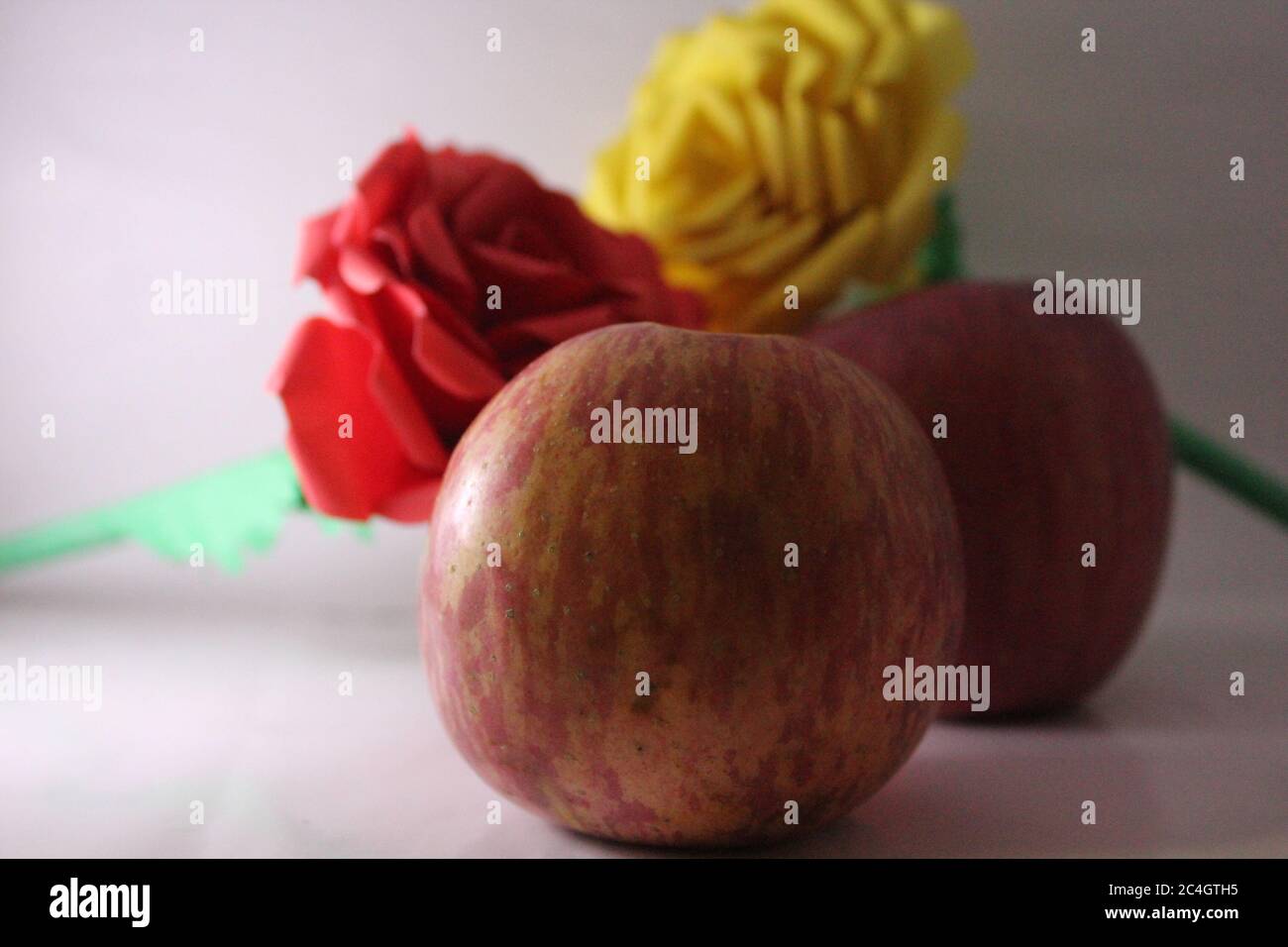 Due mele e rosa di colore diverso Foto Stock