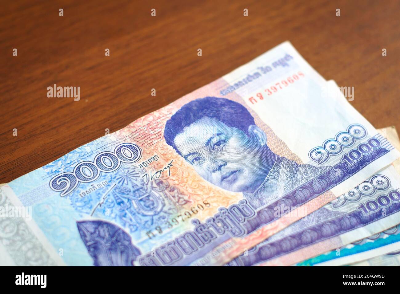 Denaro cambogiano, valuta cartacea. Un Mille Riel Bill, con l'immagine del re Norodom Sihanouk su di esso, in cima ad altre banconote cambogiane. Foto Stock
