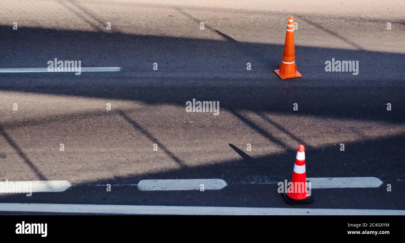 Coni riflettenti arancioni su una strada, utilizzati come misura di calmazione del traffico. Foto Stock