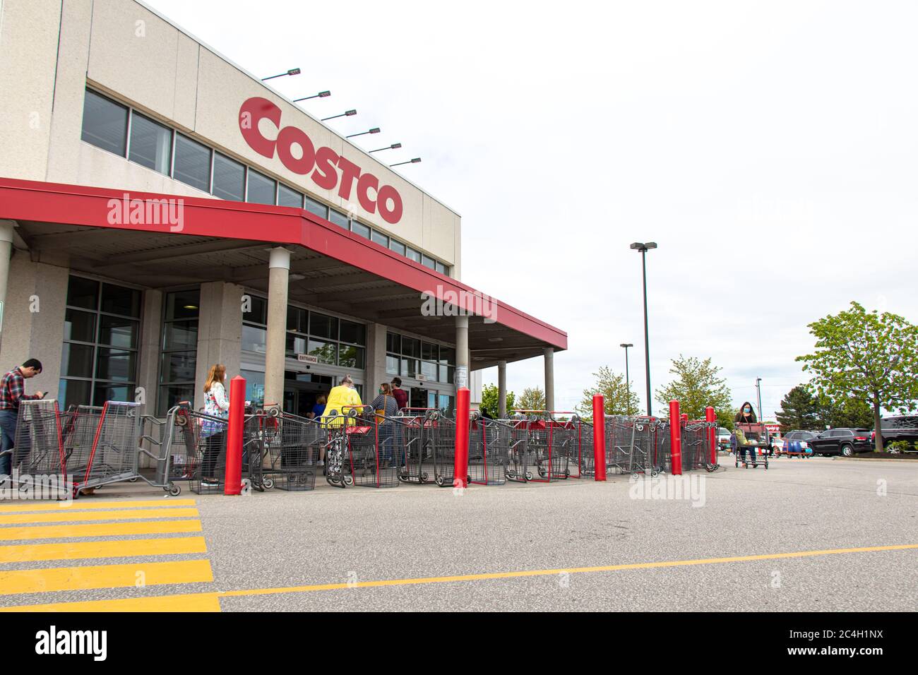 I clienti attendono in linea di entrare in un negozio all'ingrosso Costco, durante i protocolli rigorosi durante la pandemia COVID-19, Foto Stock