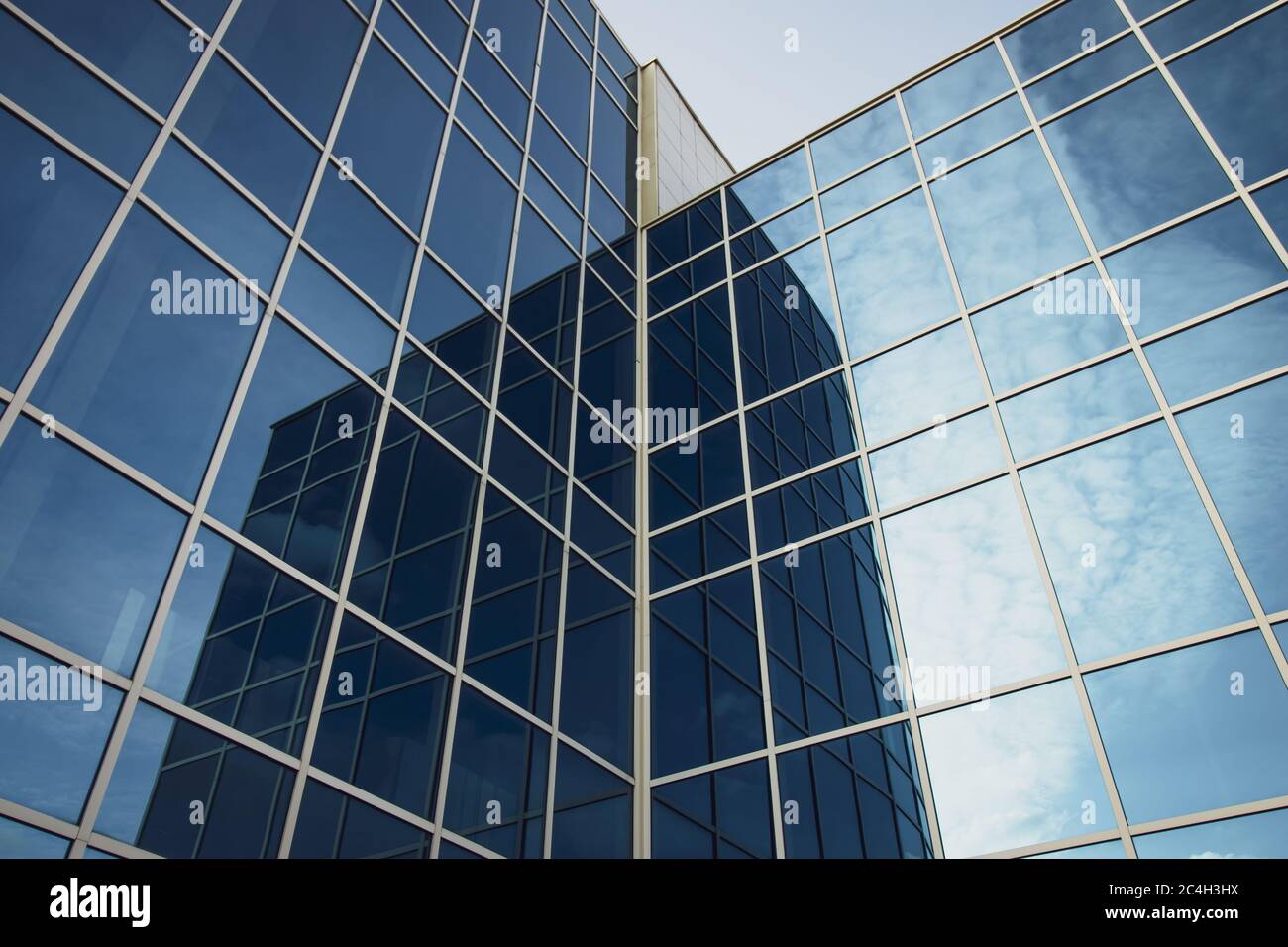 Moderno edificio di uffici con finestre di vetro e cielo blu. Struttura blu scuro di alti edifici. Astratto specchio parete sfondo di grattacielo Foto Stock