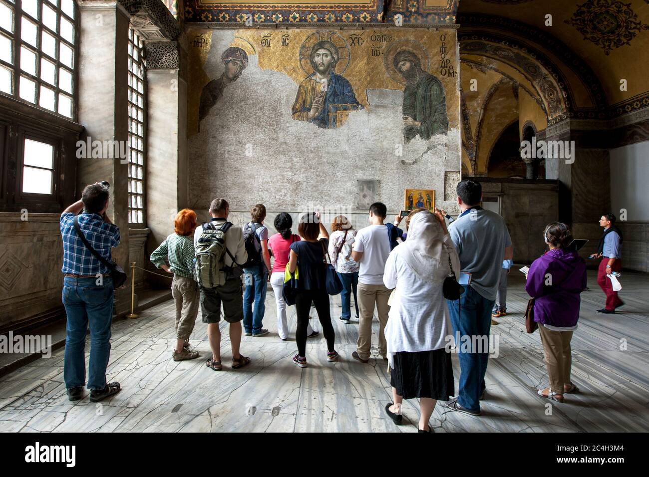 I visitatori ammirano il mosaico della Deesi del XIII secolo ad Aya Sofya, l'ex basilica di Hagia Sophia di Costantinopoli a Istanbul, Turchia. Foto Stock