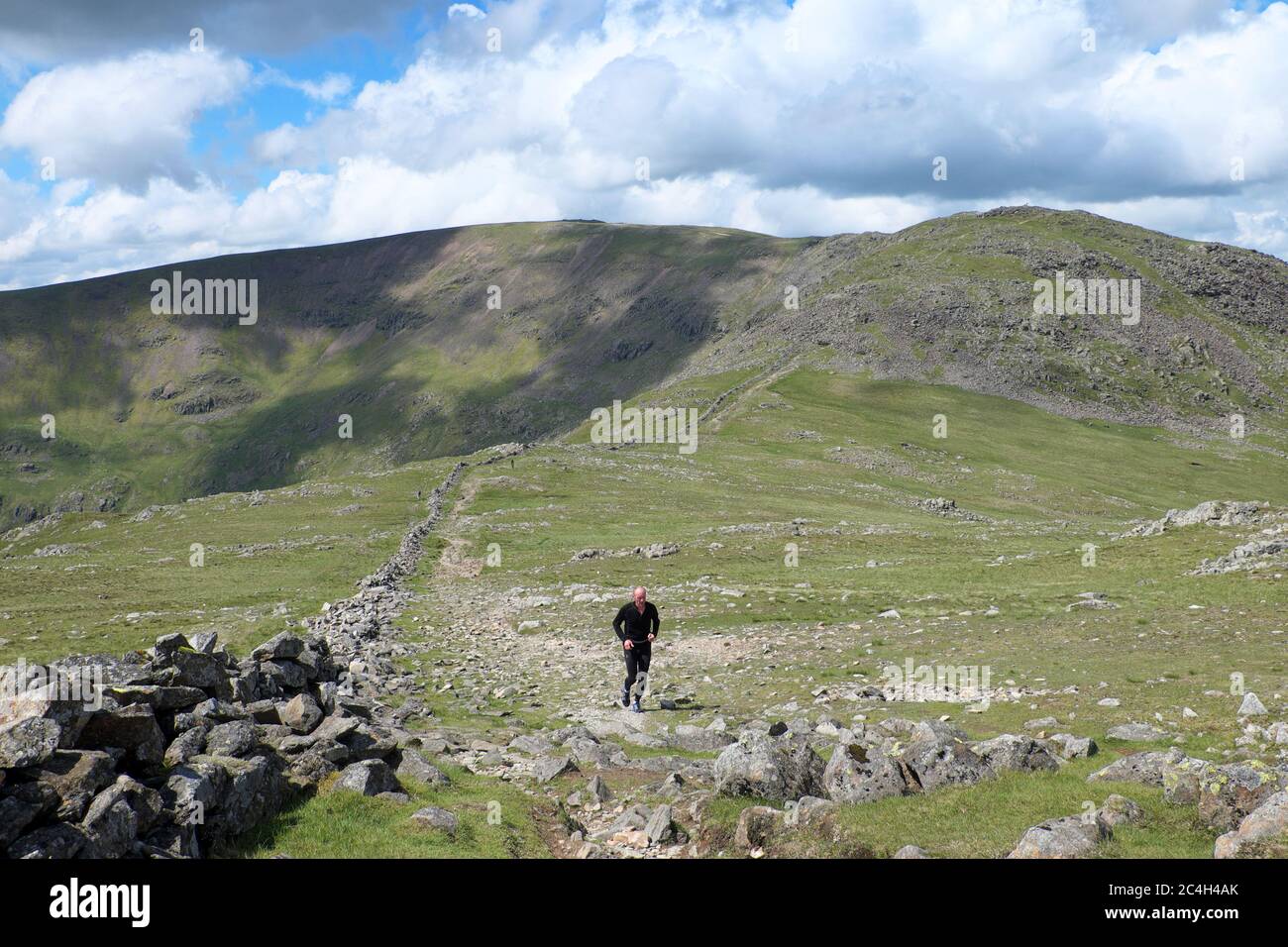 Fell Runner tra Hart Crag e dove Crag sul Fairfield Horseshoe nel Lake District National Park e patrimonio dell'umanità dell'UNESCO Foto Stock