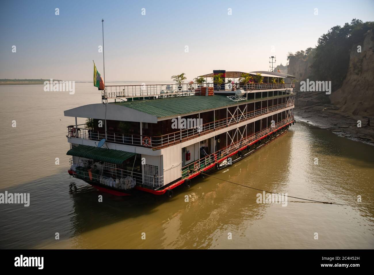 Nave da crociera sul fiume Irrawaddy, Myanmar. Scena idilliaca, acqua calma, Cruiser fiume colorato attende i passeggeri Foto Stock
