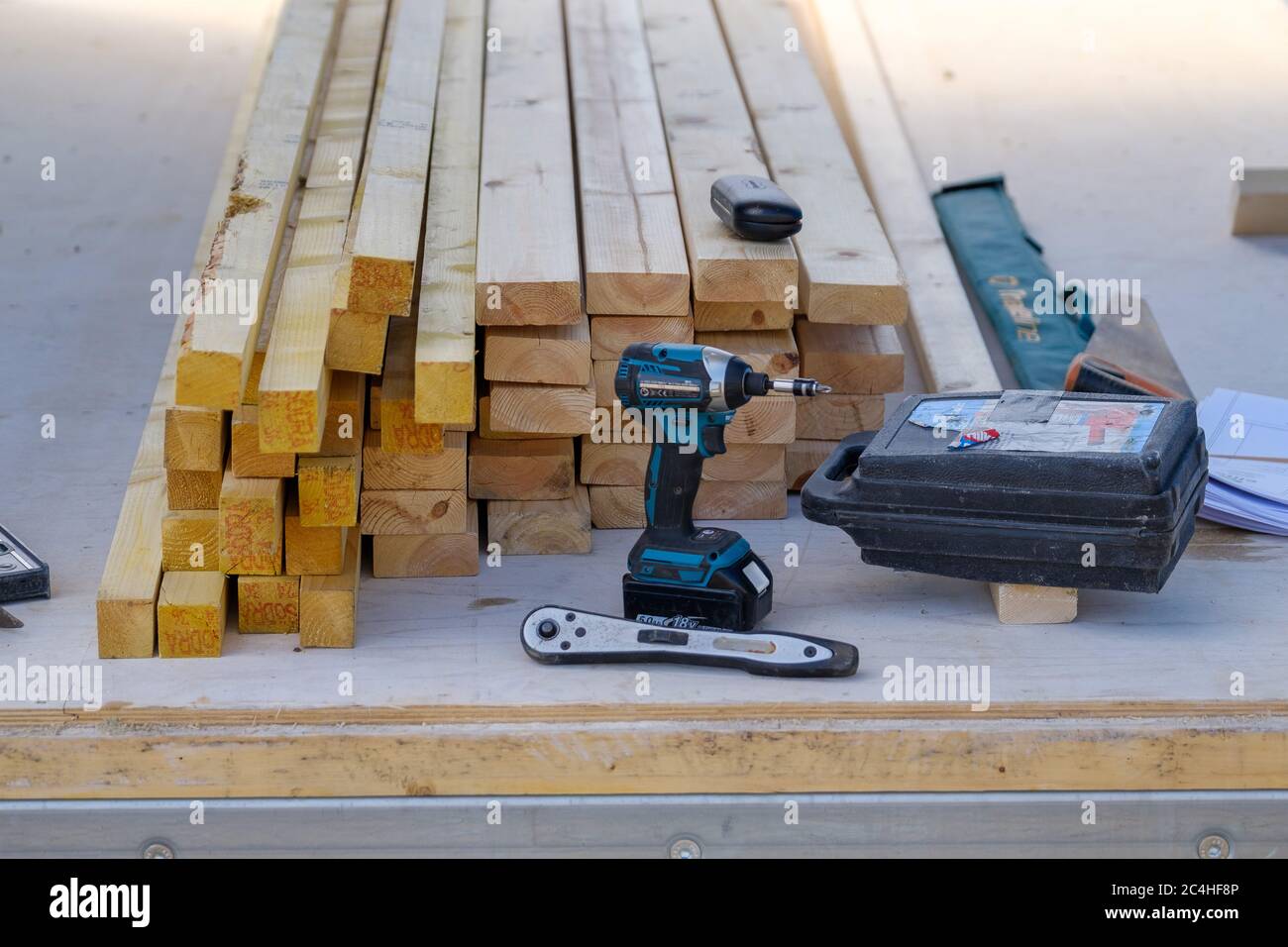 Pila di legno con attrezzi di falegname e trapano elettrico Foto Stock