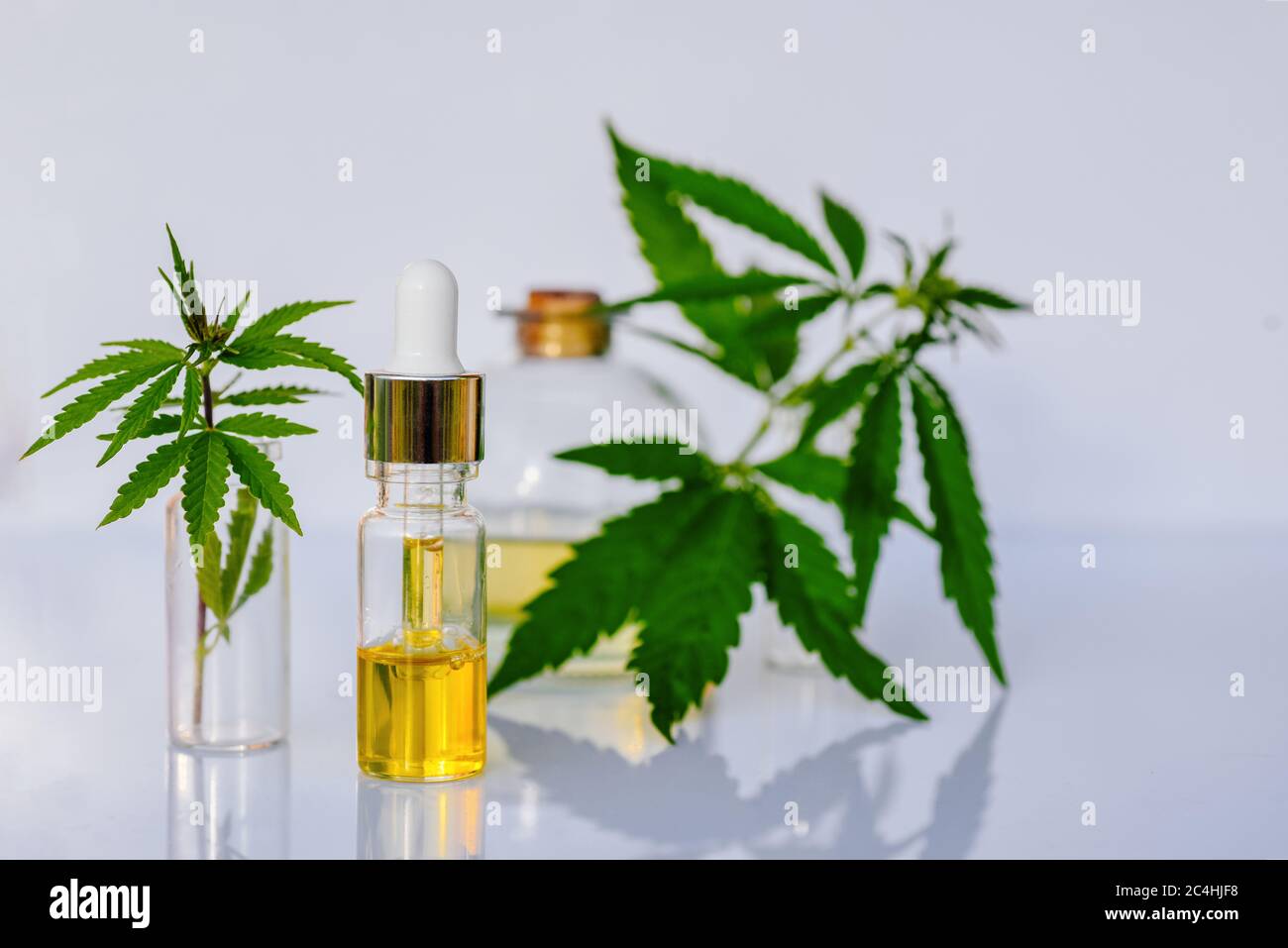 Tintura farmaceutica di olio e cannabis nel CBD su un banco di laboratorio bianco Foto Stock