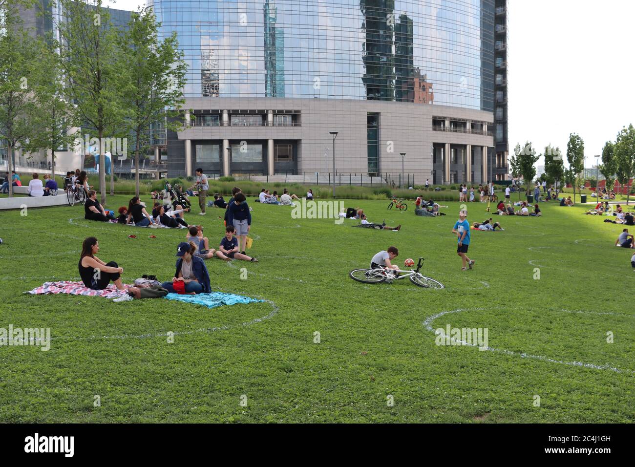 Zona porta Nuova - Milano - Italia - vivere all'aperto durante l'emergenza Covid 19, Milano. I segni sull'erba aiutano le persone a mantenere la distanza sociale. Foto Stock