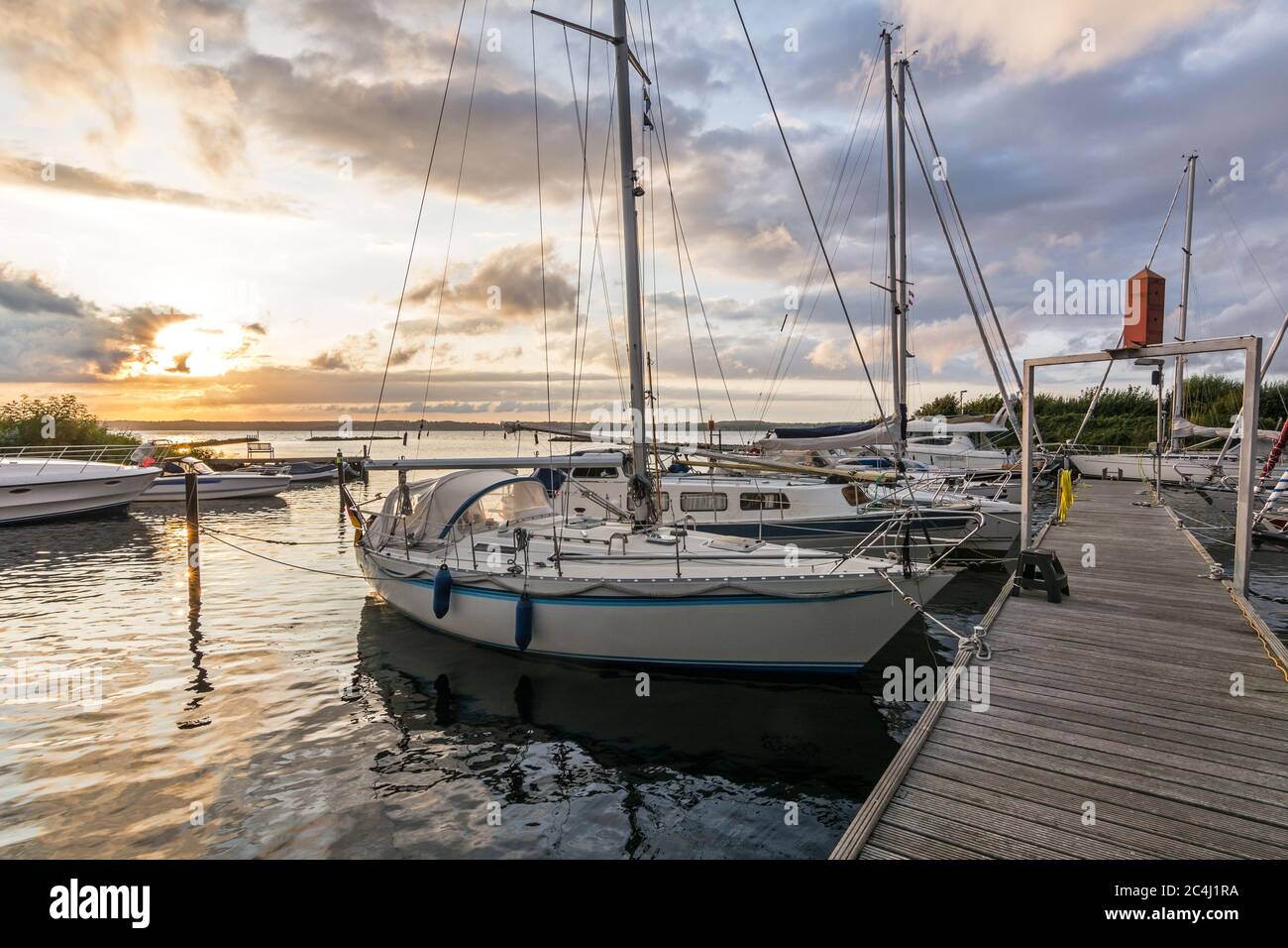 Barche a vela in un porto turistico durante un bellissimo tramonto colorato al Mar Baltico Foto Stock