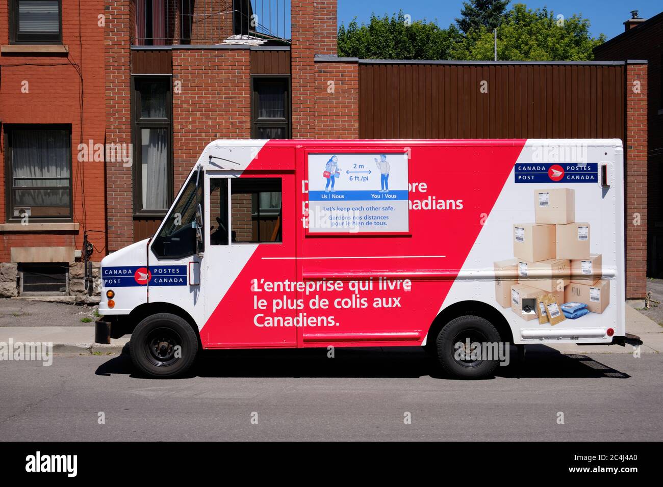 Canada Post consegna camion parcheggiato su strada residenziale mentre effettuazione consegna con Covid 19 display Foto Stock