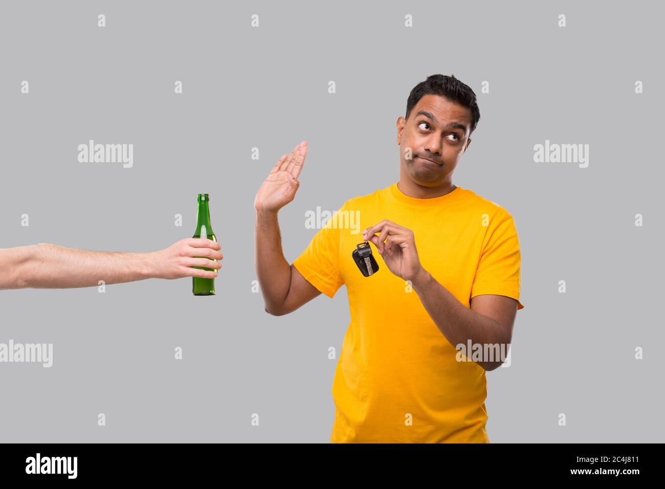 L'uomo indiano che dice No alla bottiglia della birra che tiene le chiavi dell'automobile. Non bere e guidare. L'uomo non beve. Non ci sono alcolici. Uomo che rifiuta l'alcol Foto Stock