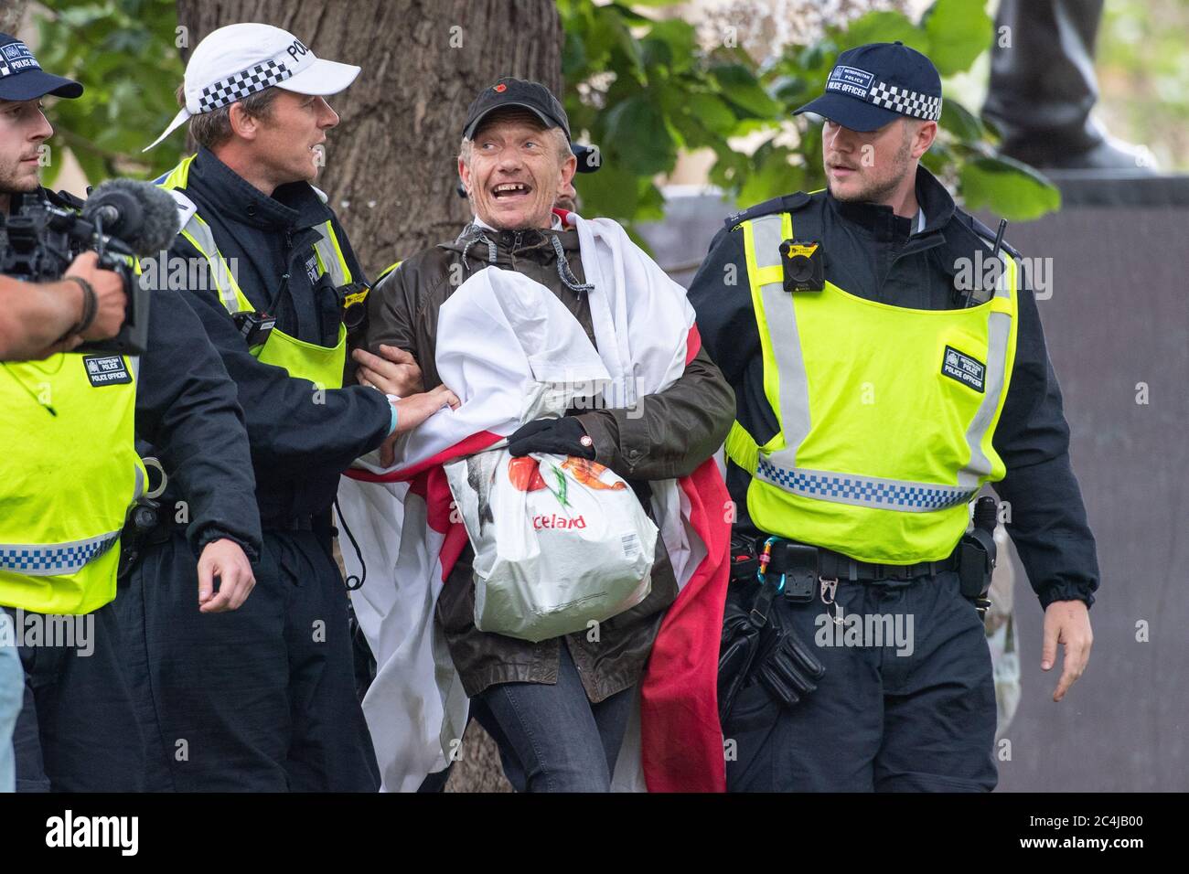 La polizia ha portato via un contro protestore ad un raduno di Justice for Shukri Abdi a Parliament Square, Londra, a seguito di una serie di proteste della materia Black Lives in tutto il Regno Unito. Foto Stock