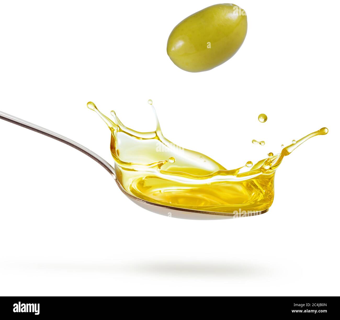 olive verdi che cadono su un cucchiaio di olio isolato su bianco Foto Stock