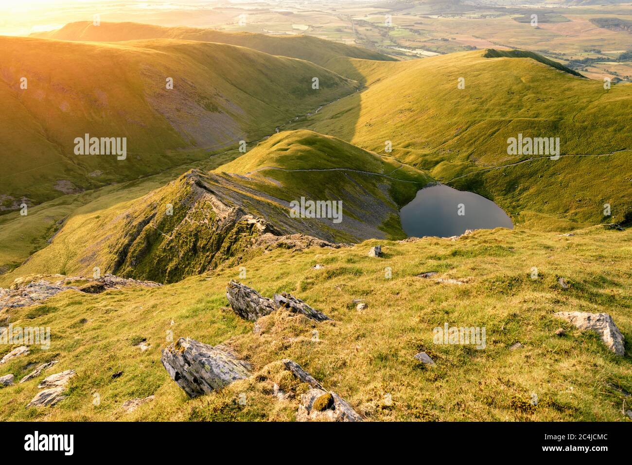 Mountain Ridge Sunrise con piccolo Tarn/lago. Lake District, Regno Unito. Foto Stock