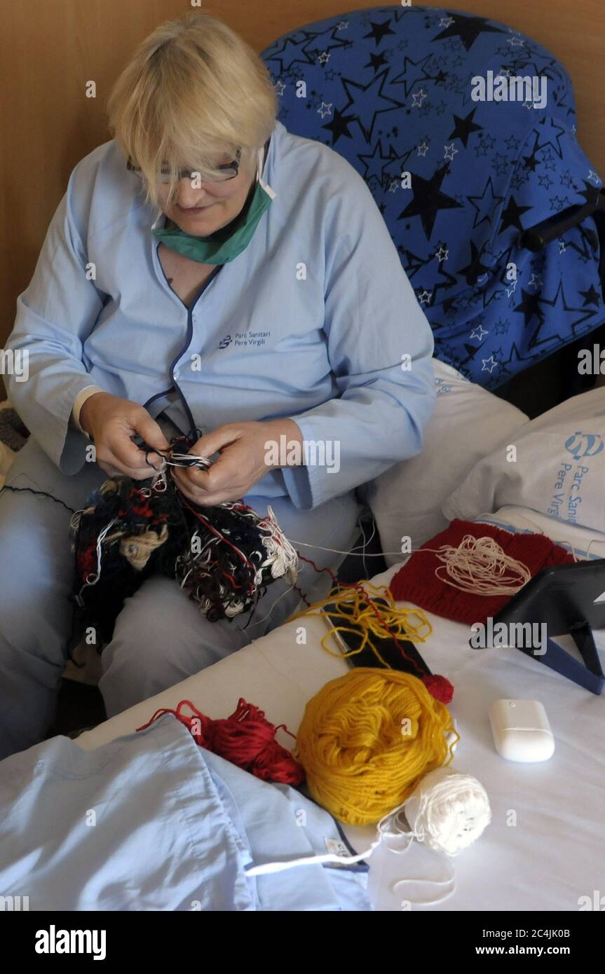 donna ospedalizzata che trascorre tempo sgregando fili di lana, anti-stress, Foto Stock