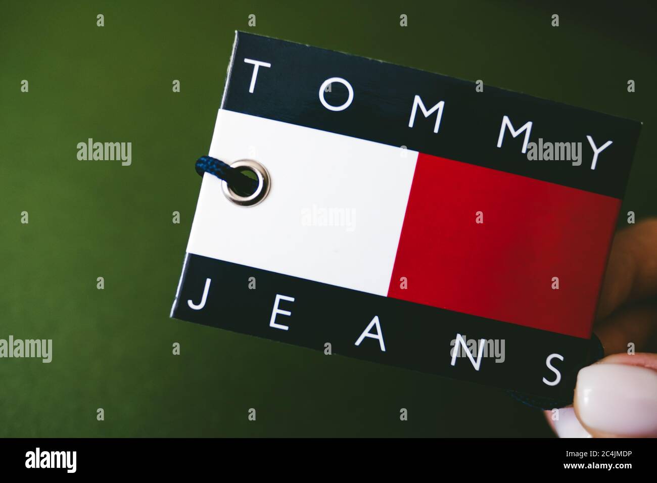 Primo piano dell'etichetta Tommy Hilfiger su sfondo verde Foto stock - Alamy