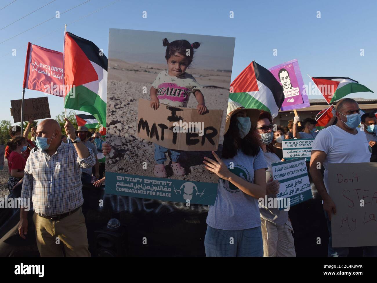 Almog Junction, Gaza. 27 giugno 2020. Donna porta un manifesto di una ragazza palestinese durante una protesta di palestinesi e israeliani contro il piano di Israele di annettere parti della Cisgiordania alla giunzione di Almog vicino a Gerico in Cisgiordania sabato 27 giugno 2020. Il primo ministro israeliano Benjamin Netanyahu afferma che gli insediamenti ebraici nei territori palestinesi potrebbero essere annessi da Israele già dal 1° luglio. Foto di Debbie Hill/UPI Credit: UPI/Alamy Live News Foto Stock