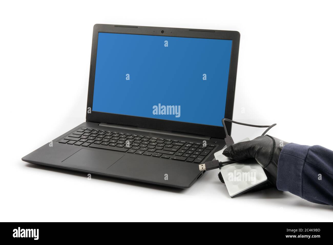 Un hacker di computer che inserisce un disco rigido esterno USB in un computer per rubare i dati Foto Stock