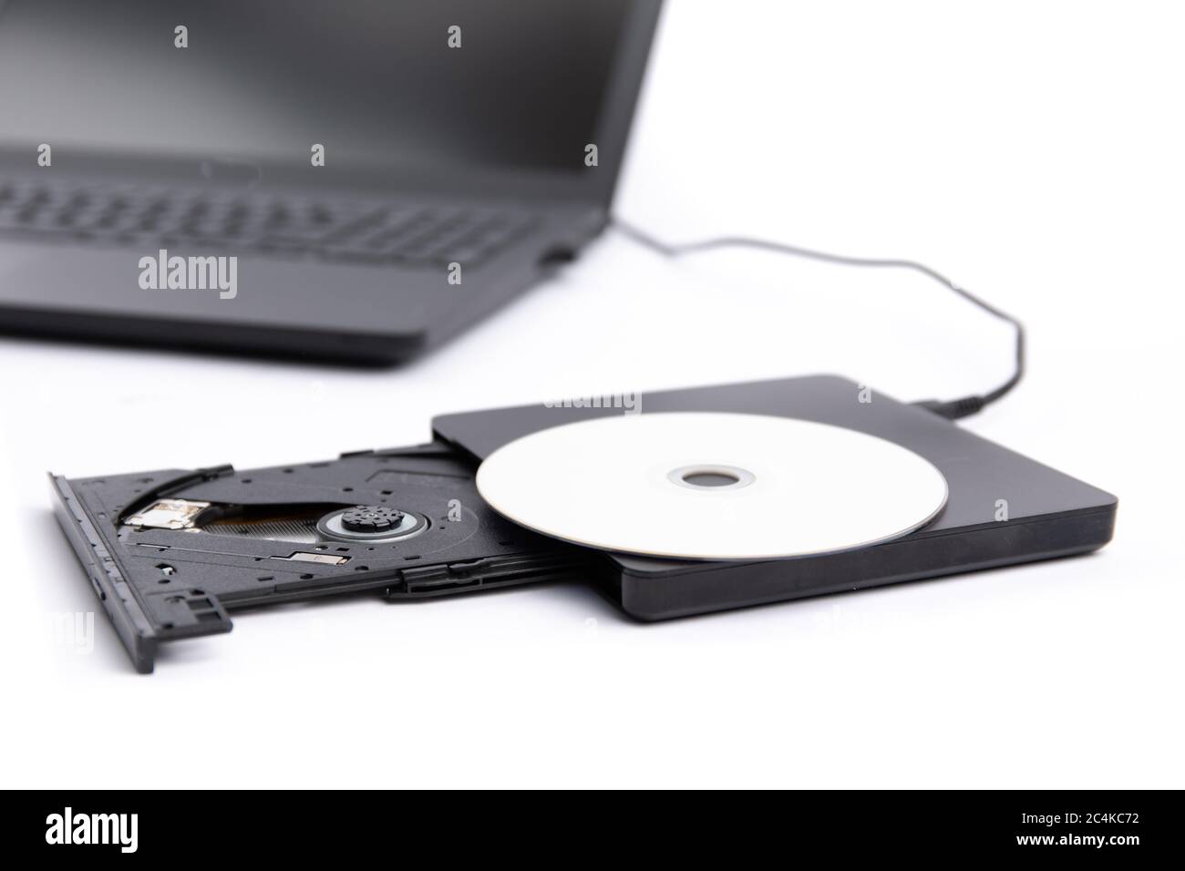 Primo piano di un lettore DVD esterno aperto collegato a un computer  notebook nero isolato su bianco Foto stock - Alamy
