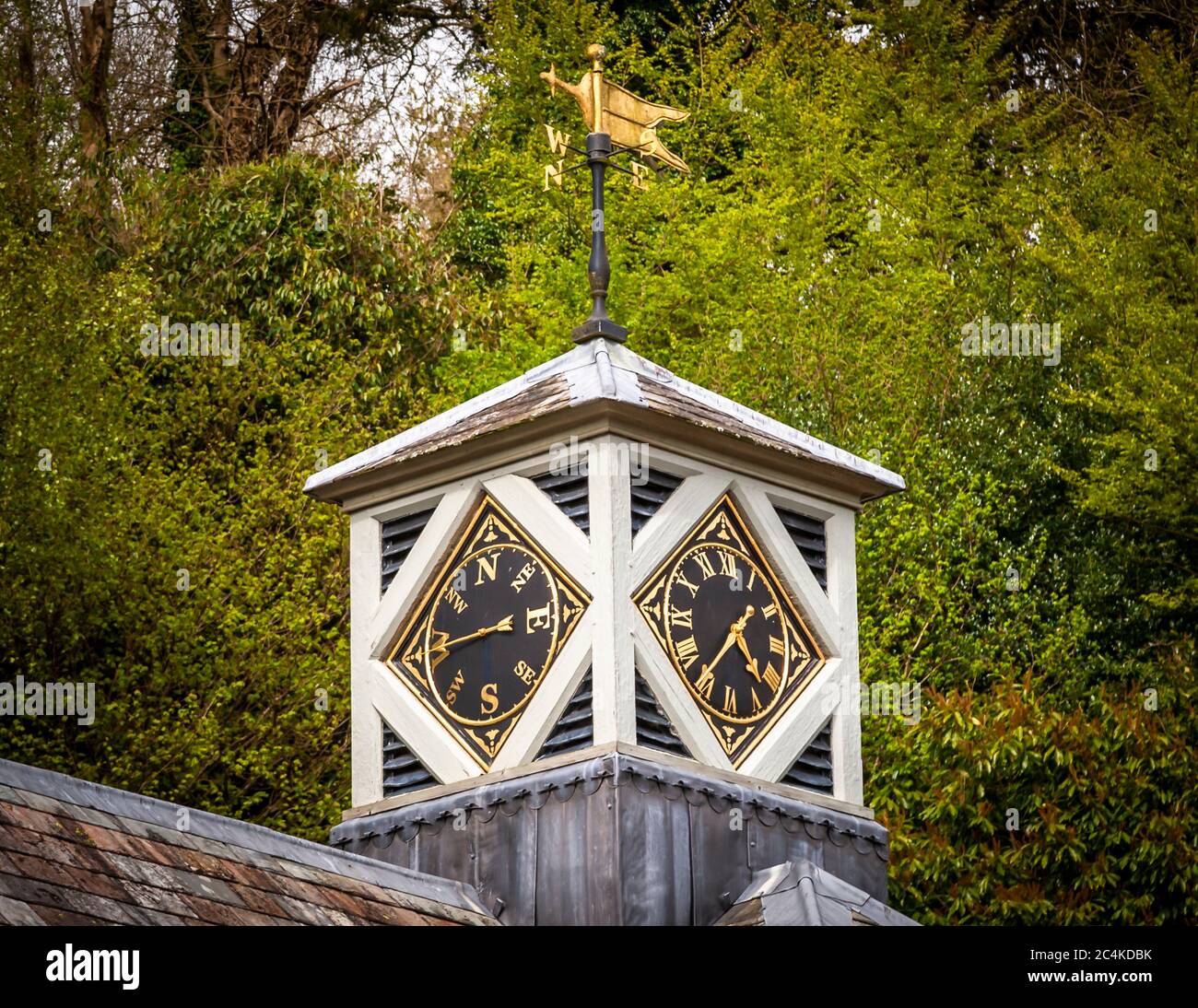 Una torre dell'orologio corona il tetto dell'Hotel Endsleigh a West Devon, in Inghilterra, i suoi due quadranti mostrano l'ora e i punti cardinali sotto una banderuola dorata a forma di quello che sembra essere una volpe in corsa. Olga Polizzi, direttrice del design del gruppo Rocco Forte Hotels, ha restaurato la tenuta vincolata come hotel nel 2004. Foto Stock