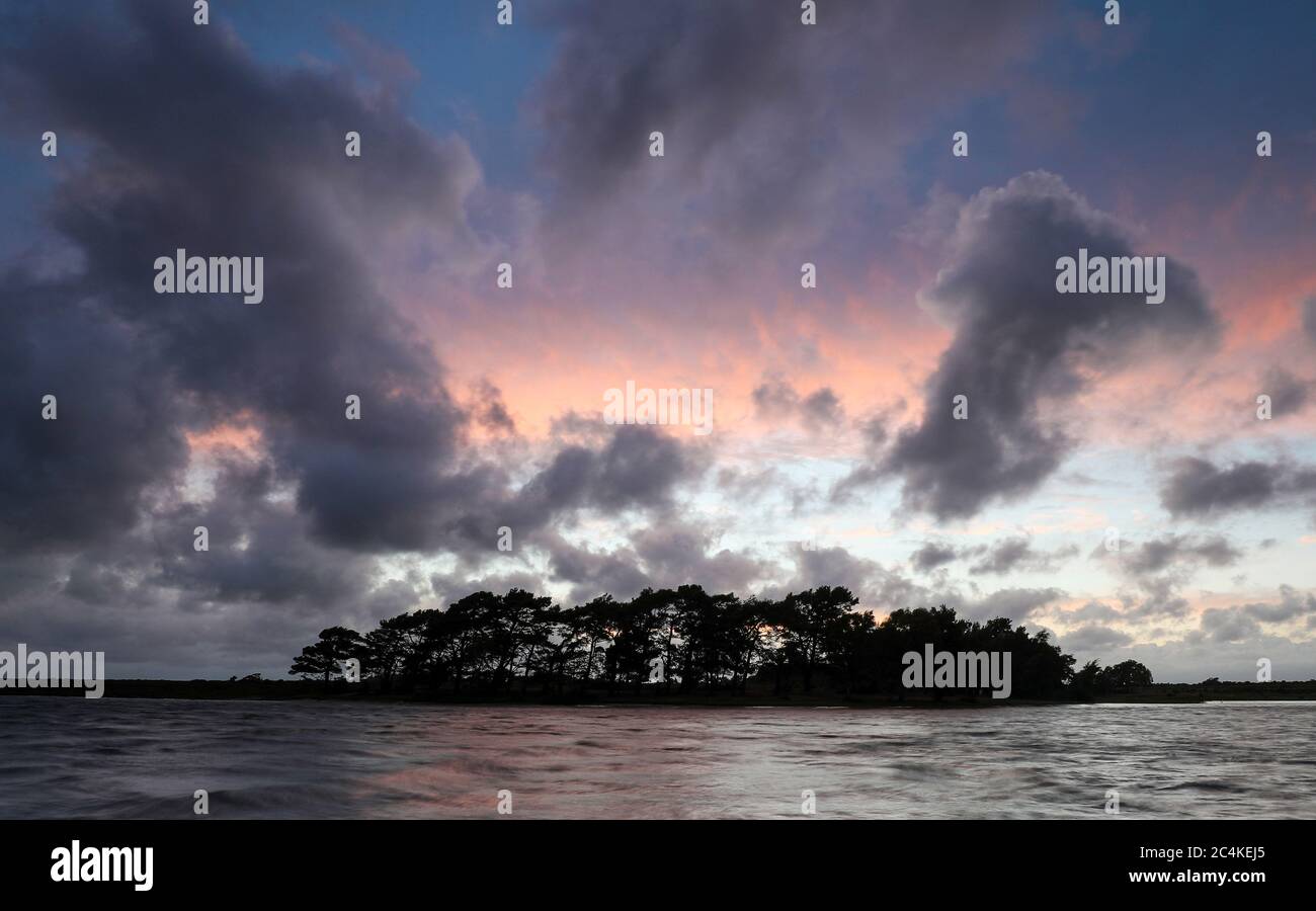 New Forest, Hampshire. 27 giugno 2020. Regno Unito Meteo. Le nuvole piovose si radunano al tramonto su Hatchet Pond vicino a Brockenhurst nella New Forest, dopo una giornata di sole e docce. Credit Stuart Martin/Alamy Live News Foto Stock