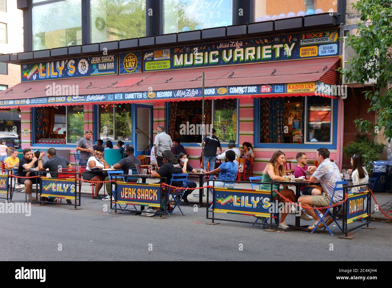 New York, New York. 25 giugno 2020. Ristoranti all'aperto socialmente distanziati fuori dal Miss Lily's nell'East Village, sotto la fase 2 riapertura di New York City. Alcuni ristoranti e bar hanno una capacità maggiore convertendo i corridoi di parcheggio in parchi, marciapiedi estensioni sulla strada per ristoranti e per il tempo libero, e non per il deposito auto. Foto Stock