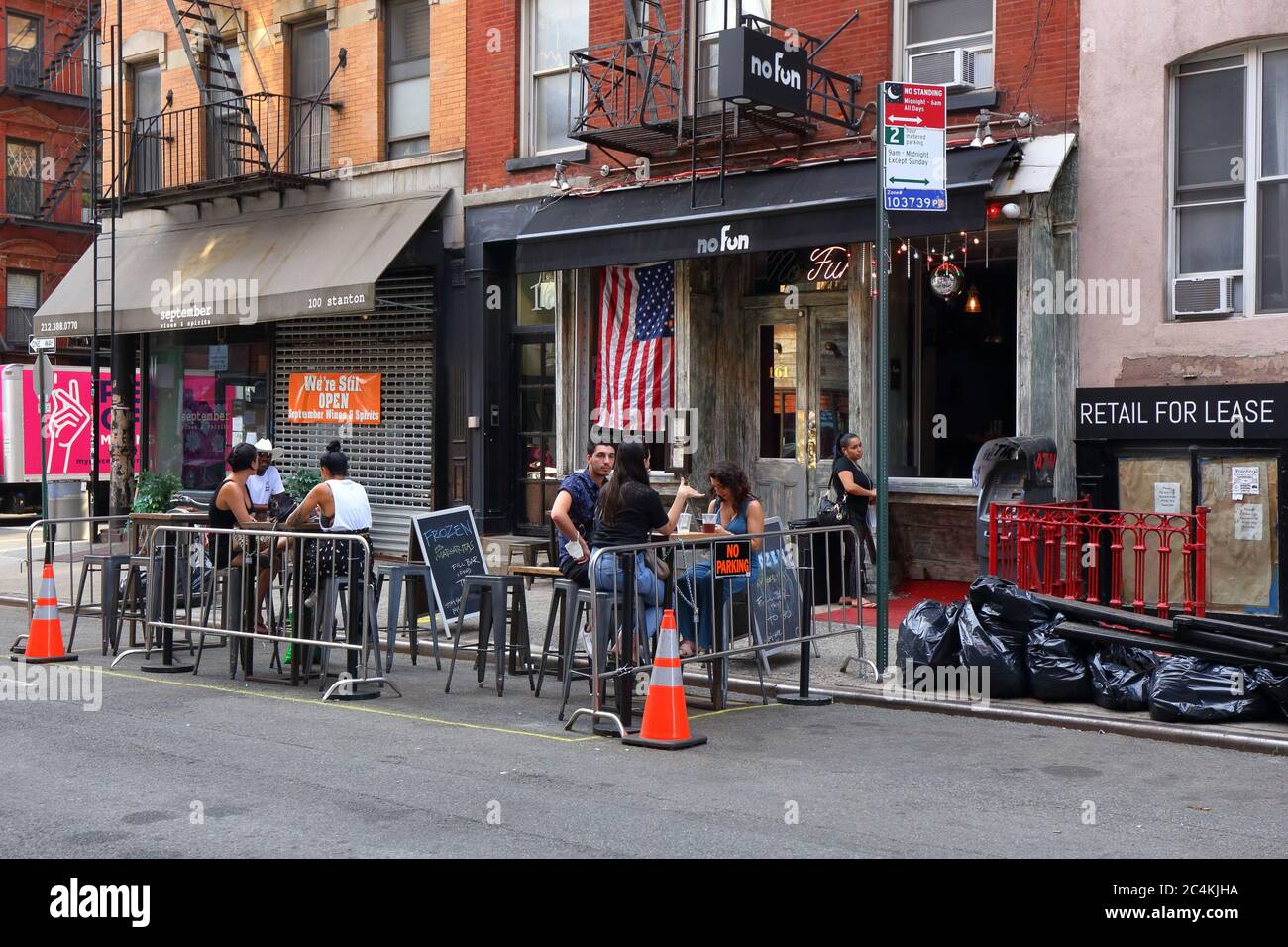 New York, New York. 25 giugno 2020. Pasti all'aperto socialmente distanziati al No Fun Bar in Ludlow Street a Manhattan, sotto la fase 2 della riapertura di New York City. Alcuni ristoranti e bar hanno una capacità maggiore convertendo i corridoi di parcheggio in parchi, marciapiedi estensioni sulla strada per ristoranti e per il tempo libero, e non per il deposito auto. Foto Stock