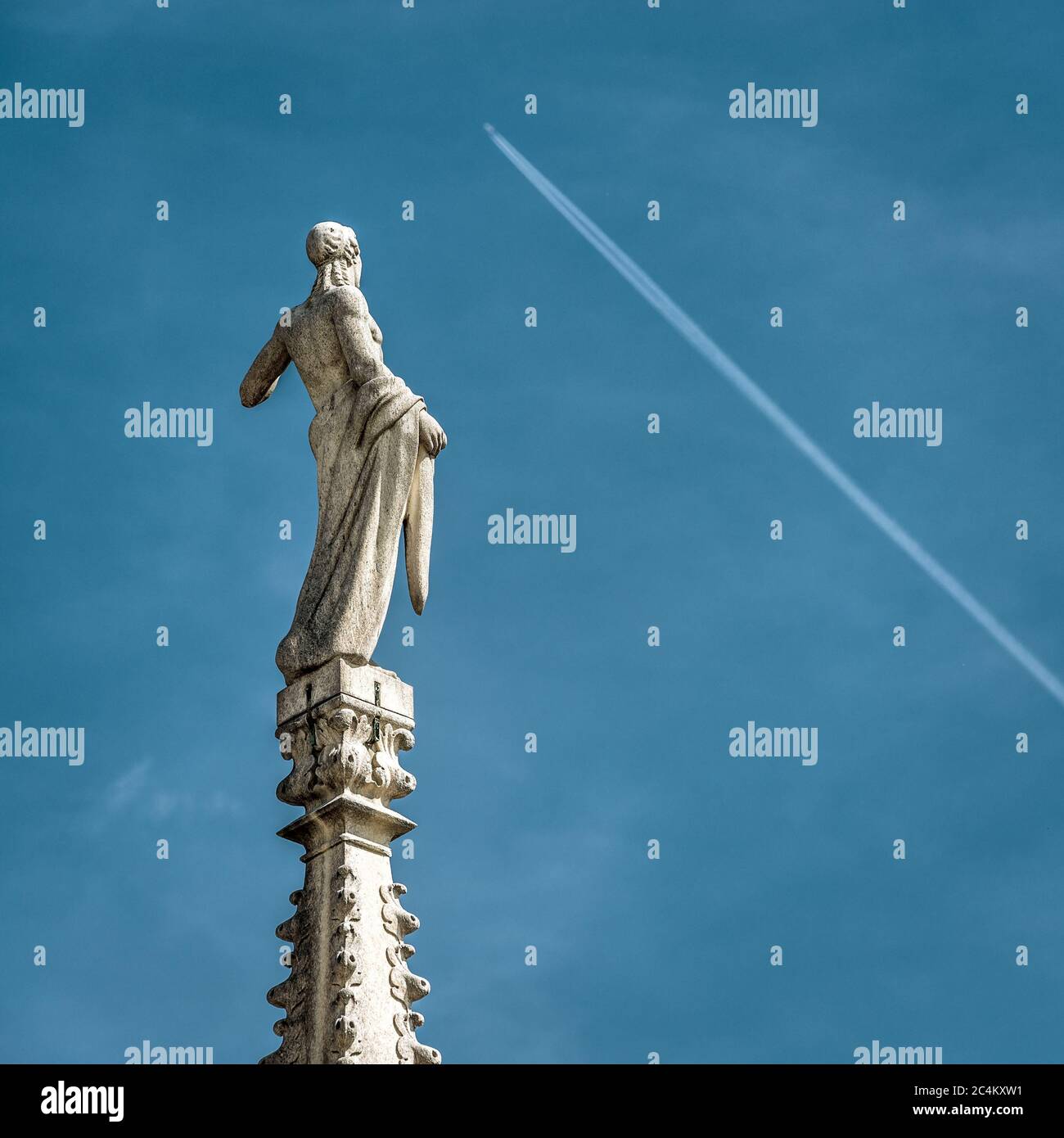 Statua sulla guglia della Cattedrale di Milano su sfondo blu cielo, Milano, Italia. Particolare del tetto gotico che si affaccia aereo volante. Concetto di viaggio, di Foto Stock