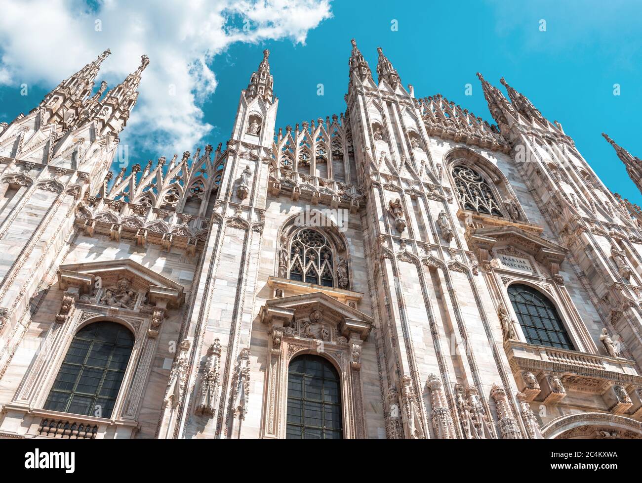 Duomo di Milano, Italia. E' un famoso punto di riferimento della citta' di Milano. Facciata di lusso del Duomo di Milano da vicino. Decorazioni gotiche su blu s. Foto Stock