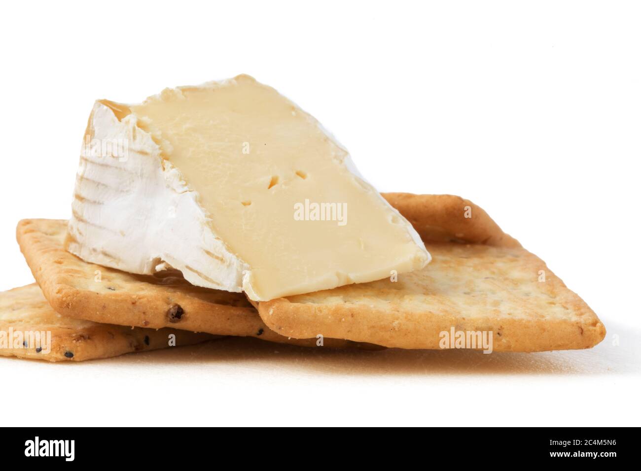 closeup estremo di un cuneo di brie formaggio con cracker multigrain isolato su bianco Foto Stock