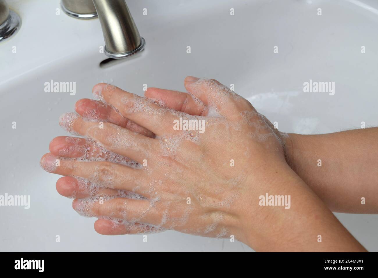 Primo piano di donna che le lavano le mani con sapone per uccidere i germi e fermare la diffusione di virus Foto Stock