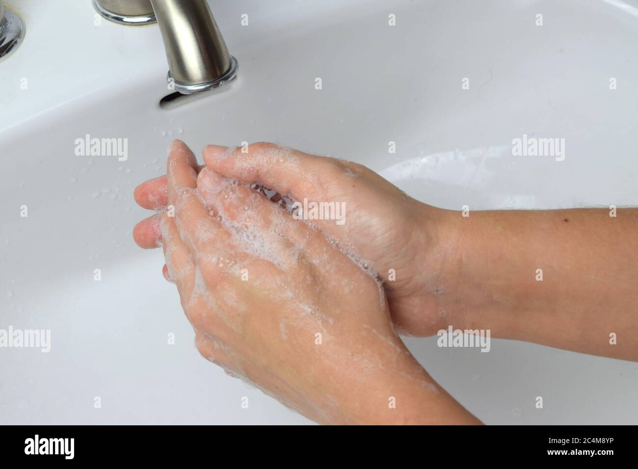 Primo piano di donna che le lavano le mani con sapone per uccidere i germi e fermare la diffusione di virus Foto Stock