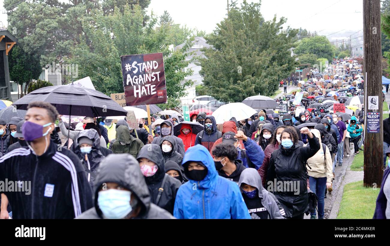 I manifestanti silenziosi marciano sotto la pioggia attraverso i quartieri di Seattle richiamando l'attenzione sul movimento Black Lives Matter e sulla brutalità della polizia Foto Stock