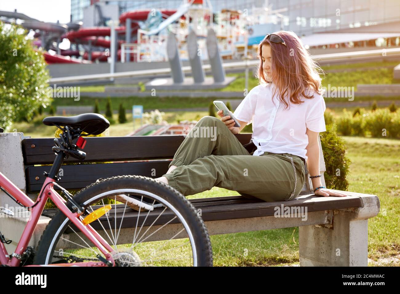 Ragazza adolescente in bicicletta urbana con telefono, bicicletta in città. Stile di vita attivo. Foto Stock