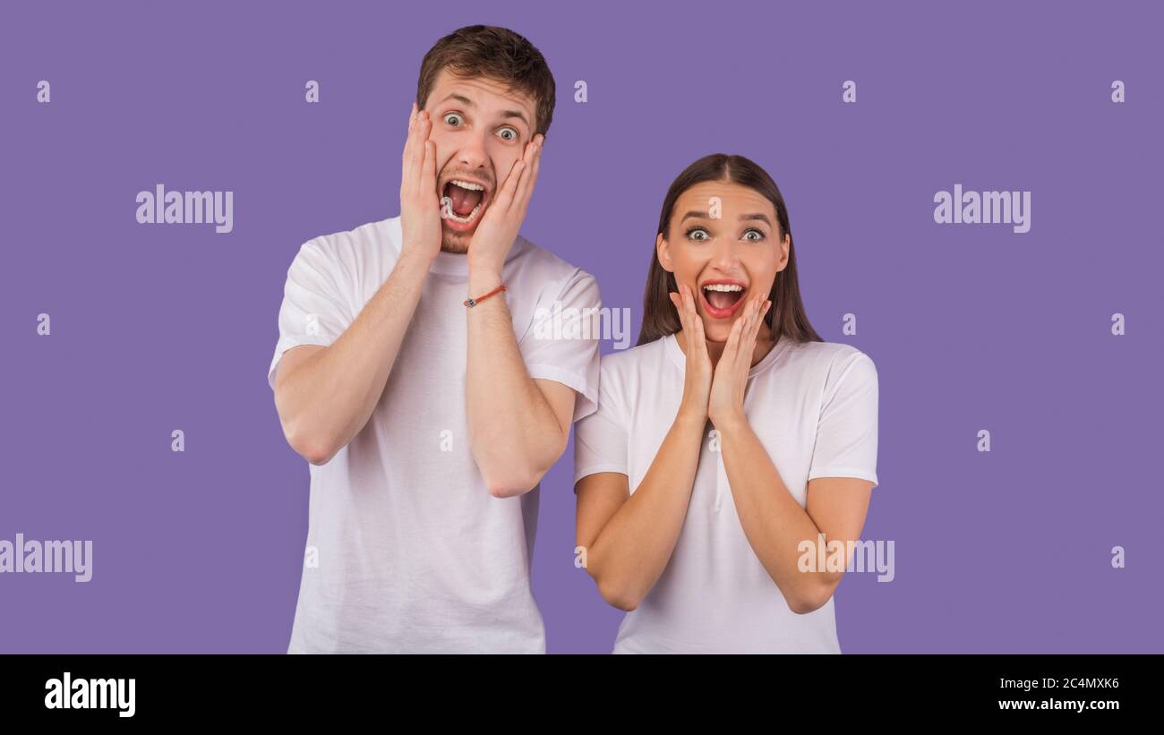 Giovane coppia entusiasta urlando felicemente in camera in studio Foto Stock