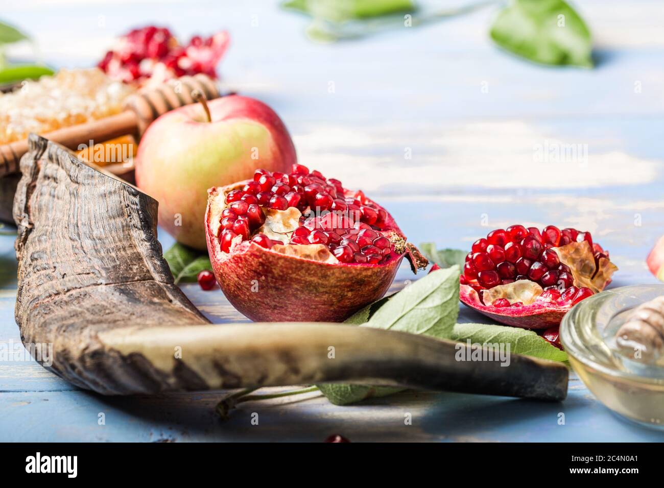 Rosh hashanah (Hashana) - concetto ebraico di Capodanno. Simboli tradizionali: Vaso di miele e mele fresche con melograno e shofar - corno su un bl Foto Stock