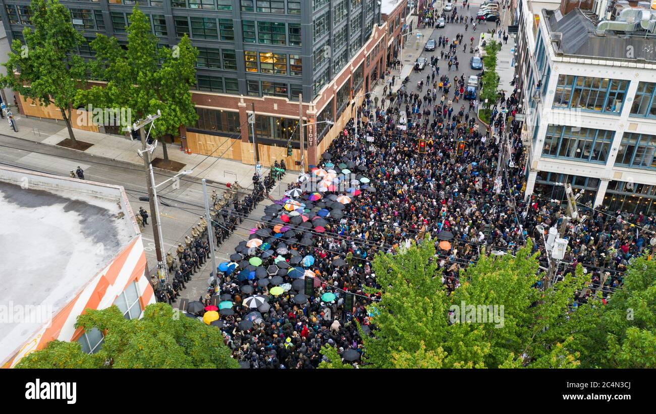 Una folla si assembla con ombrelloni per affrontare con la polizia a Capital Hill Seattle Foto Stock