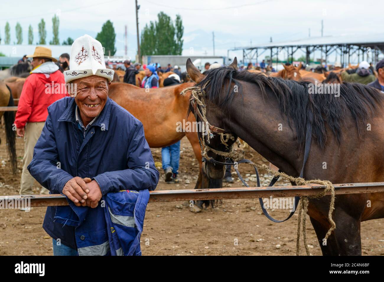 Mercato animale a Karakol, Kirghizistan. Uomo che mostra i denti. Foto Stock