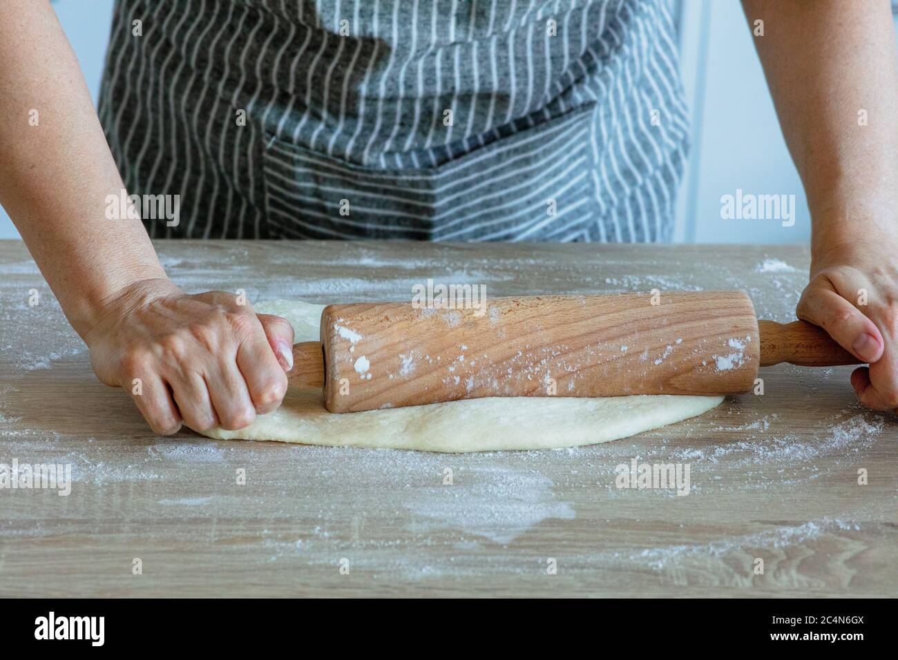 stendere la pasta di lievito con un rullo di pasta di legno Foto Stock