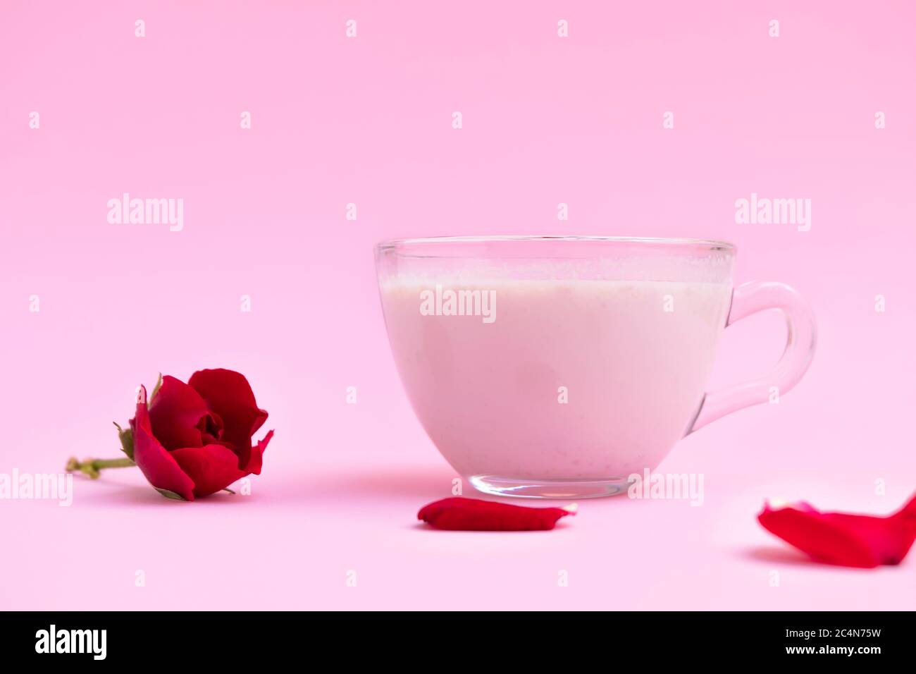 Latte di luna rosa da letto in una tazza di vetro su sfondo rosa pastello con spazio per il testo Foto Stock