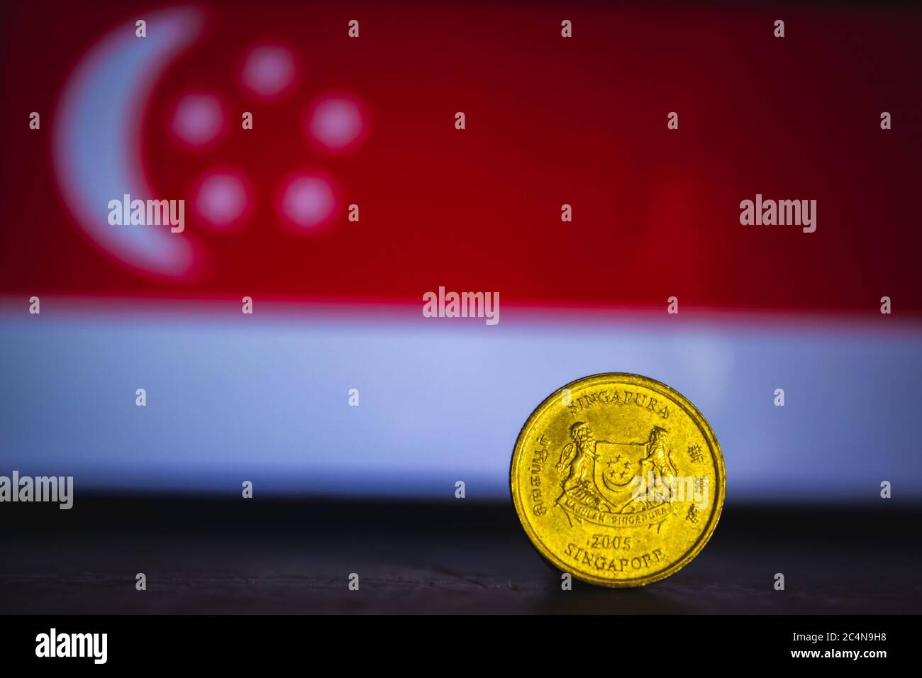 Singapore moneta - moneta da cinque centesimi di singapore isolata sullo sfondo della bandiera di singapore. Moneta da 5 cent di Singapore con spazio per la copia di testo Foto Stock