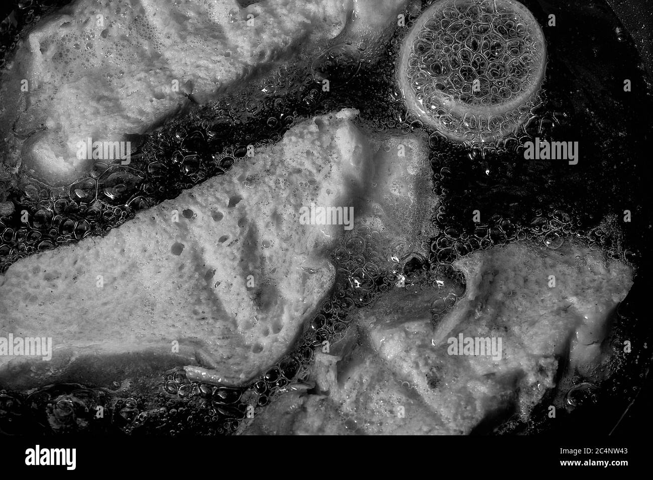 Primo piano in scala di grigi della frittura di omelette di pane in una padella Foto Stock