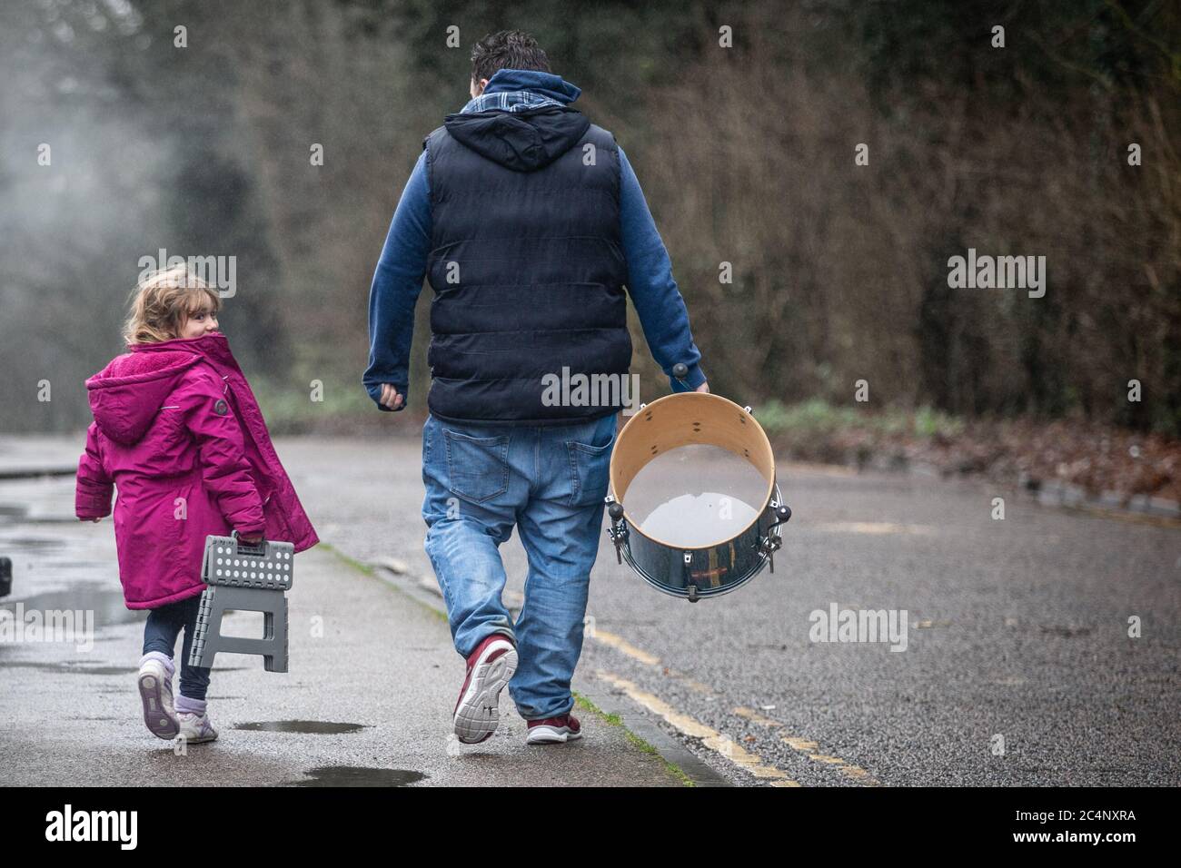 Padre e sua giovane figlia tifosi di calcio che camminano verso la partita insieme. Foto Stock