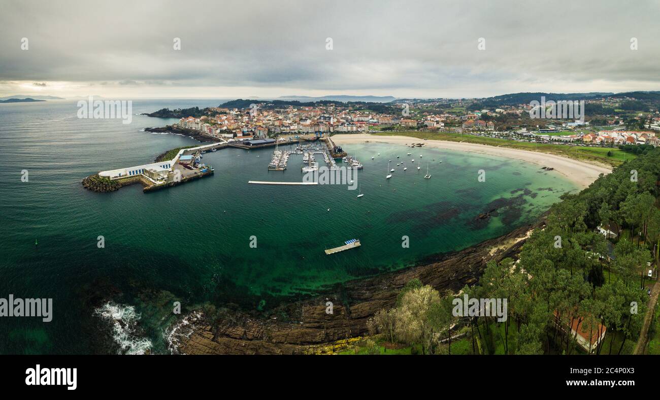 Veduta aerea del faro e del porto di Portonovo, un piccolo villaggio sulla costa della Galizia, Spagna, con le isole Cies e Ons nel backgroun Foto Stock