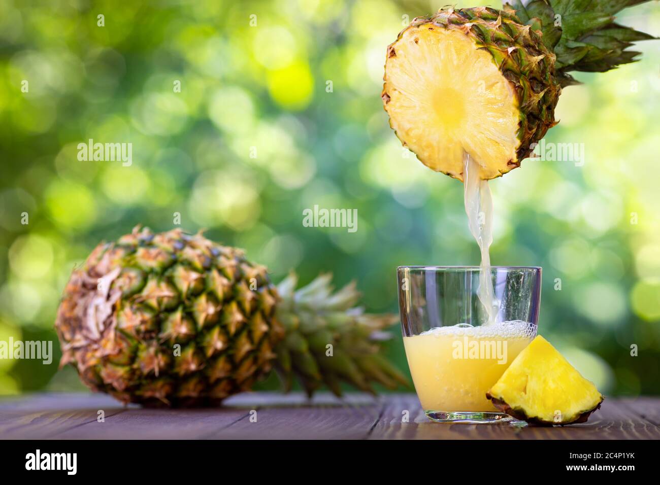 succo di ananas che si versa in un bicchiere Foto Stock