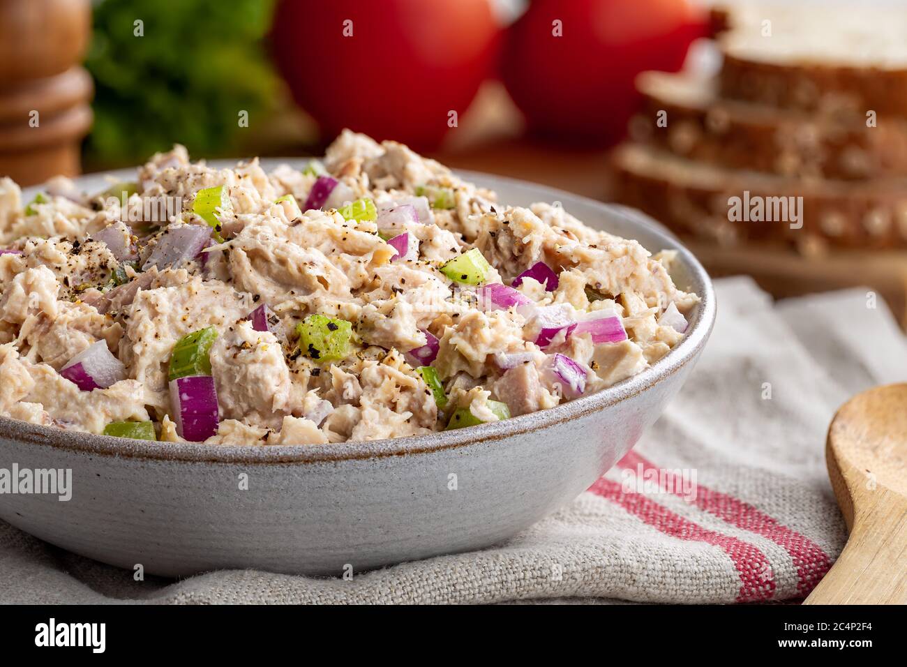 Insalata di tonno in una ciotola su un tovagliolo con making per panini in background Foto Stock