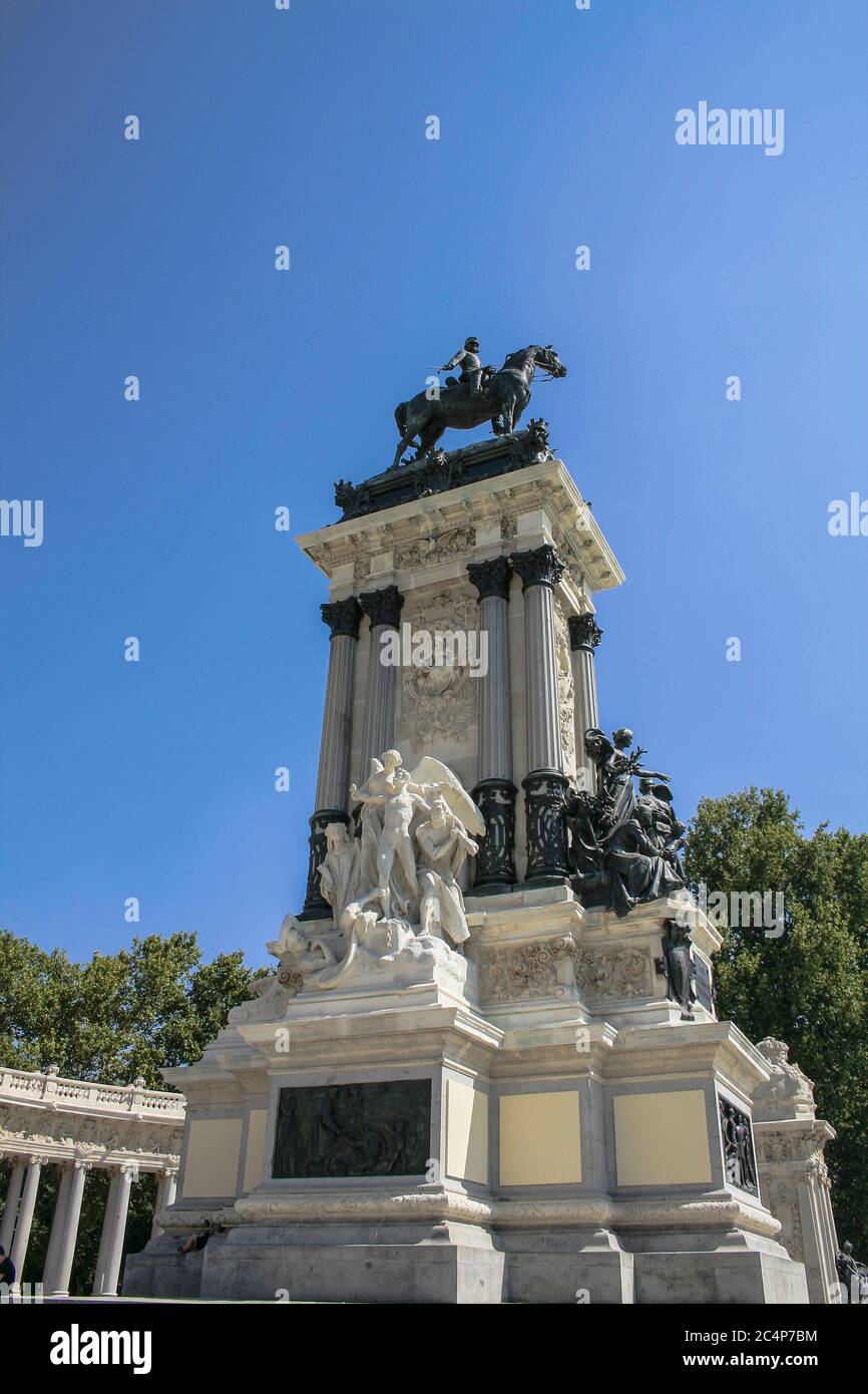 Madrid, Comunidad de Madrid, Spagna, Europa.. Parco El Retiro (Parque del Retiro). Statua del Re Alfonso XII, che fa parte di un gruppo costituito da un grande colonnato in marmo con numerose sculture che circondano la statua di bronzo del re. Il monumento, inaugurato il 6 giugno 1922, è stato costruito dall'architetto José Grases Riera. Alla base a sinistra, il gruppo scultoreo Liberty, calcareo di Aniceto Marinas (1866-1953). A destra, Peace, gruppo scultoreo bronzeo di Miquel Blay (1866-1936). Foto Stock