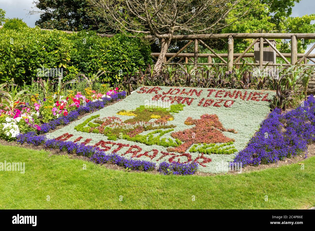 Giardini del Castello di Guildford e giardini fioriti durante l'estate, Surrey, Inghilterra, Regno Unito. Letto floreale dedicato al centenario dell'illustratore Sir John Tenniel Foto Stock
