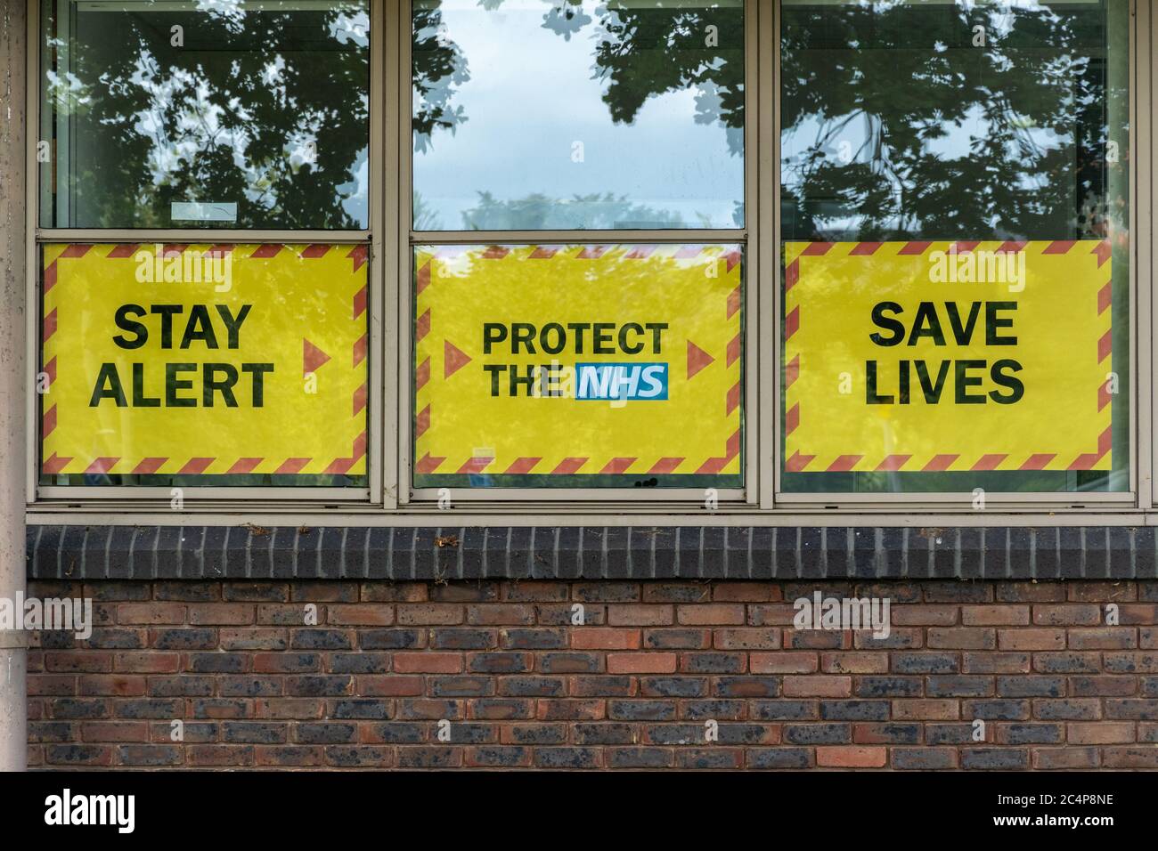 Stay Alert, Protect the NHS, Save Lives, slogan del governo britannico durante la pandemia del coronavirus covid-19, giugno 2020, sulla finestra degli uffici locali del consiglio Foto Stock