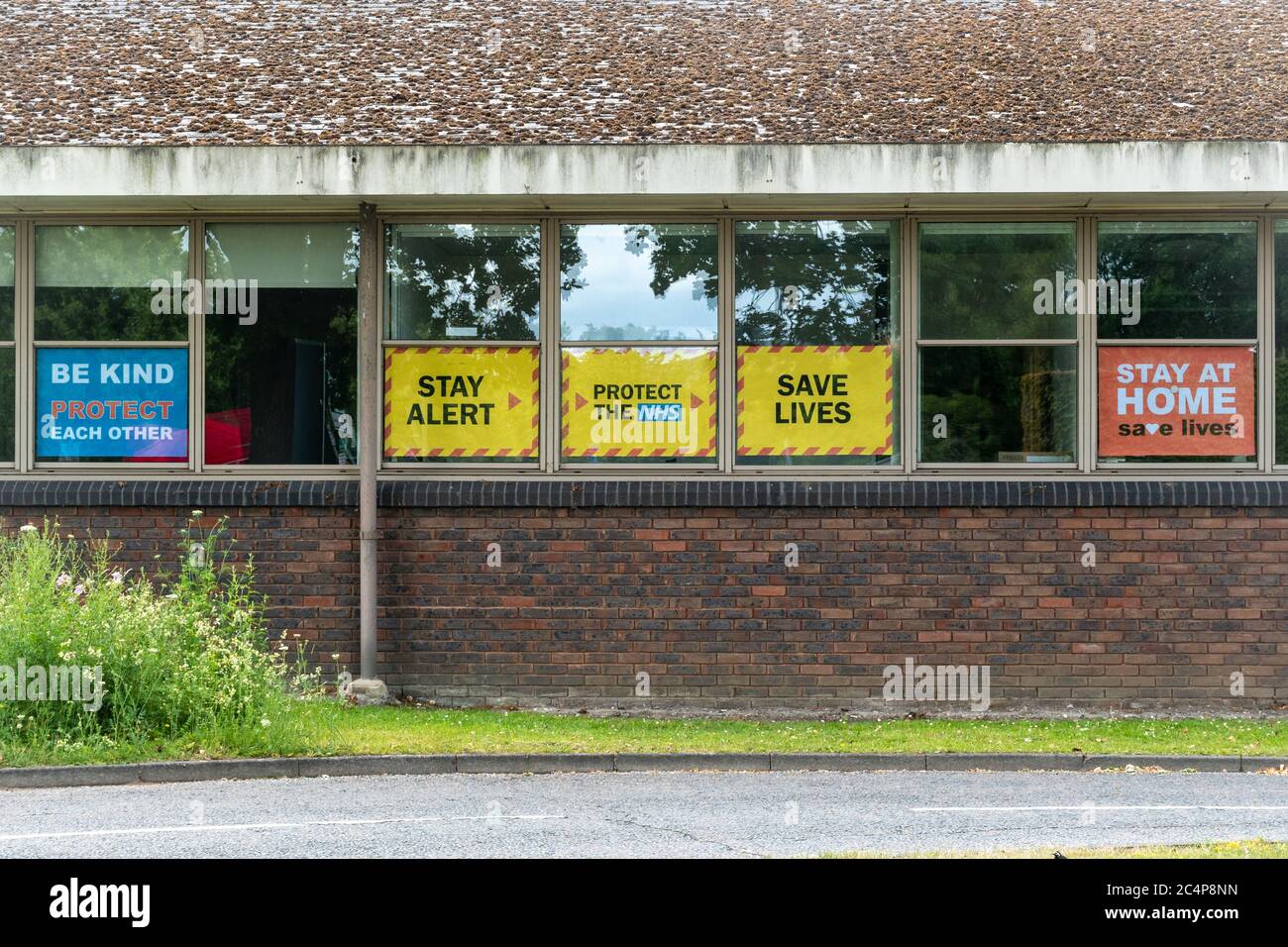 Stay Alert, Protect the NHS, Save Lives, slogan del governo britannico durante la pandemia del coronavirus covid-19, giugno 2020, sulla finestra degli uffici locali del consiglio Foto Stock