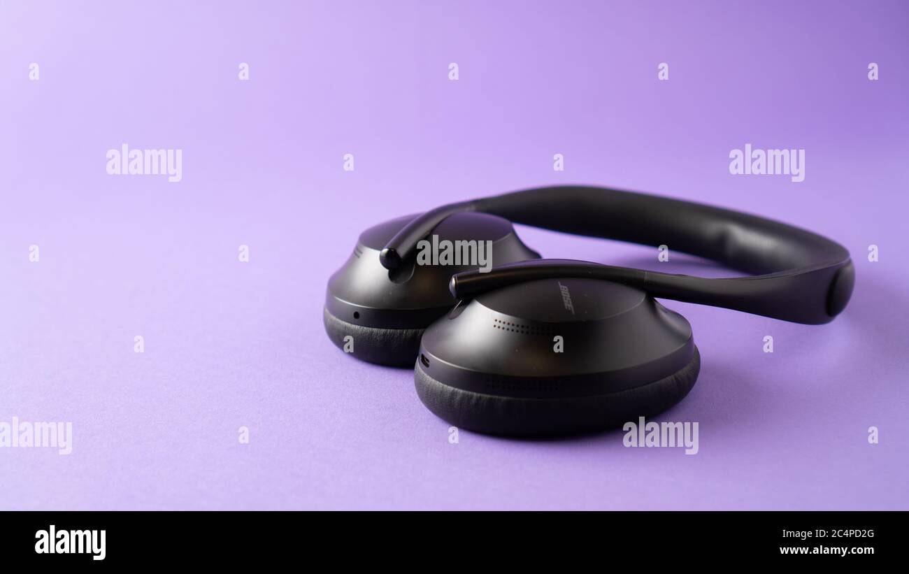 cuffie con cancellazione del rumore e microfono di qualità. cuffie wireless nere su sfondo viola. Foto Stock